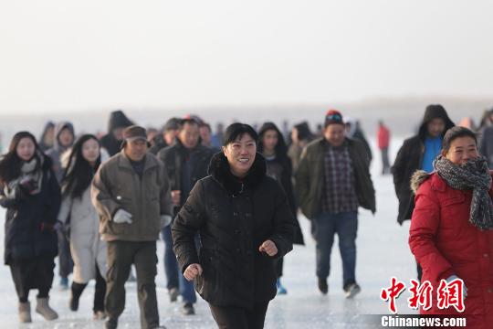 800余名冰上馬拉松競賽選手 “全副武裝”前行，他們在千里冰封的博斯騰湖面上劃出一條閃亮的軌跡。　年磊 攝