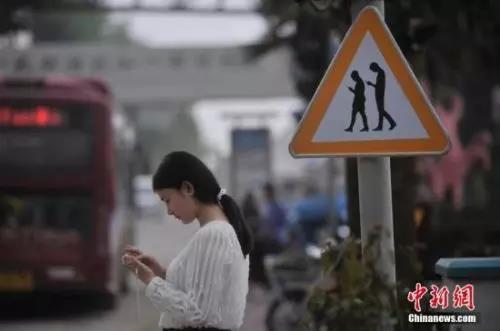 資料圖：重慶一紅綠燈處擺放“不做低頭族、關注紅綠燈”警示牌。 陳超 攝